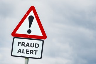A road sign saying "Fraud Alert" with an exclamation mark above it.
