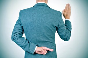 Man swearing an oath with crossed fingers behind his back.