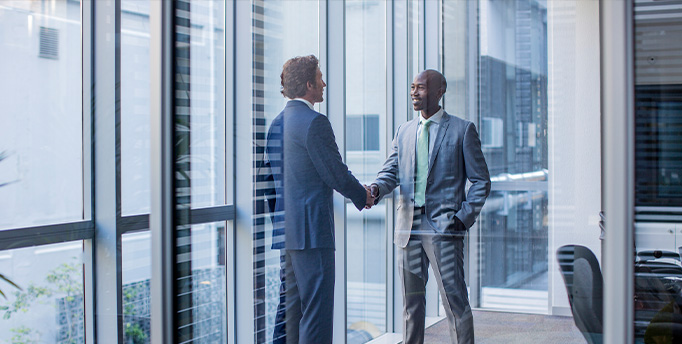 an image of a handshake in front of a CRE Sale-leaseback signed document